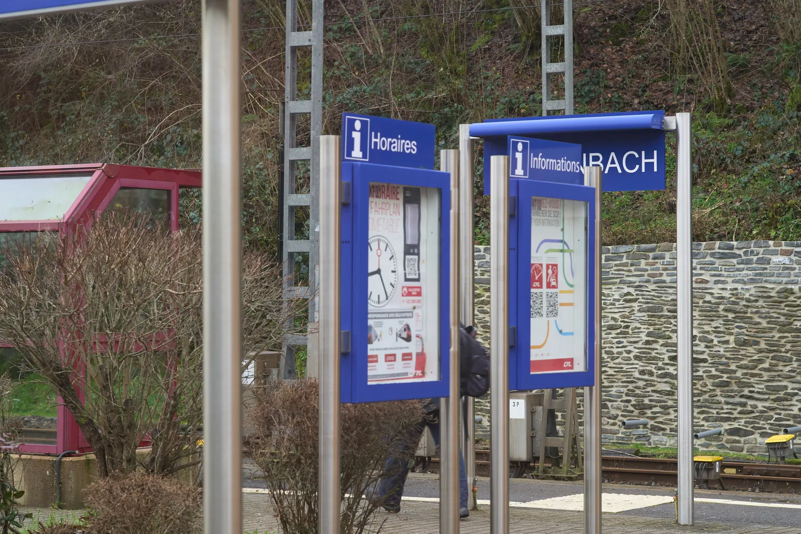 Printed on a poster on this small station in Belgium there’s a clock. It points at 25 minutes past 8.