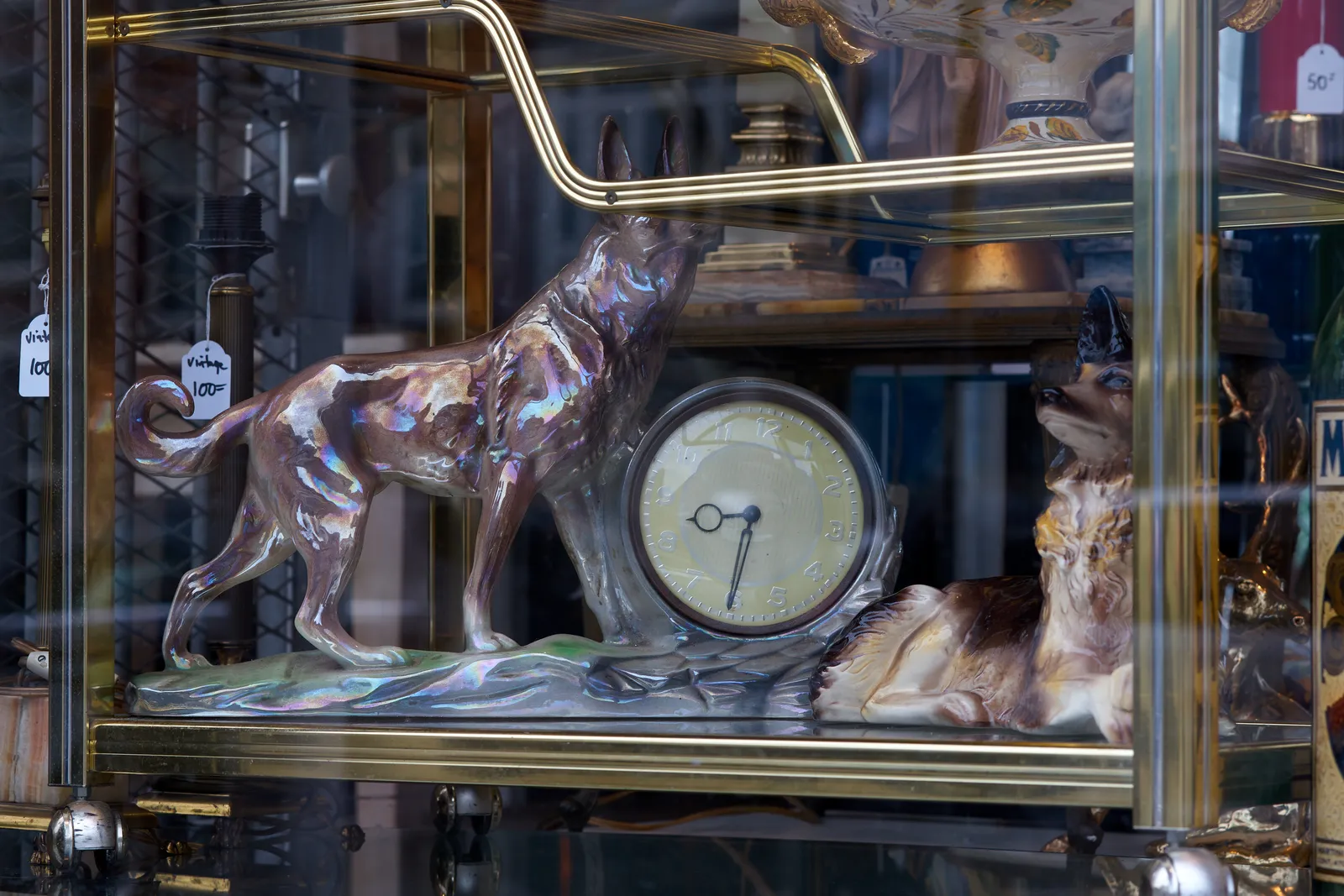 In a thrift shop there’s a clock with a statue of a wolf. The clock points at half past 8.