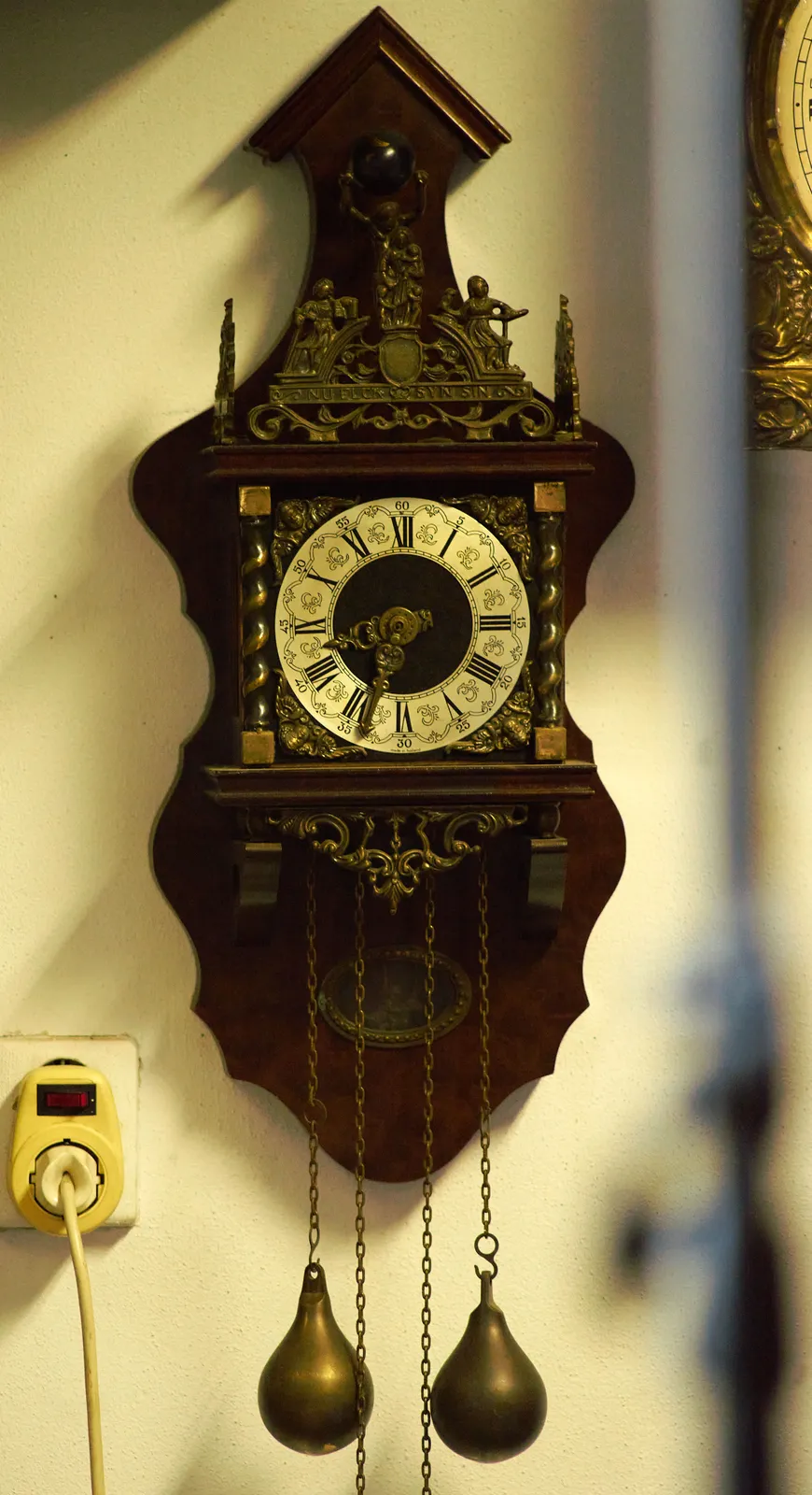An old clock with two large weights hanging below it, points at eight 33.