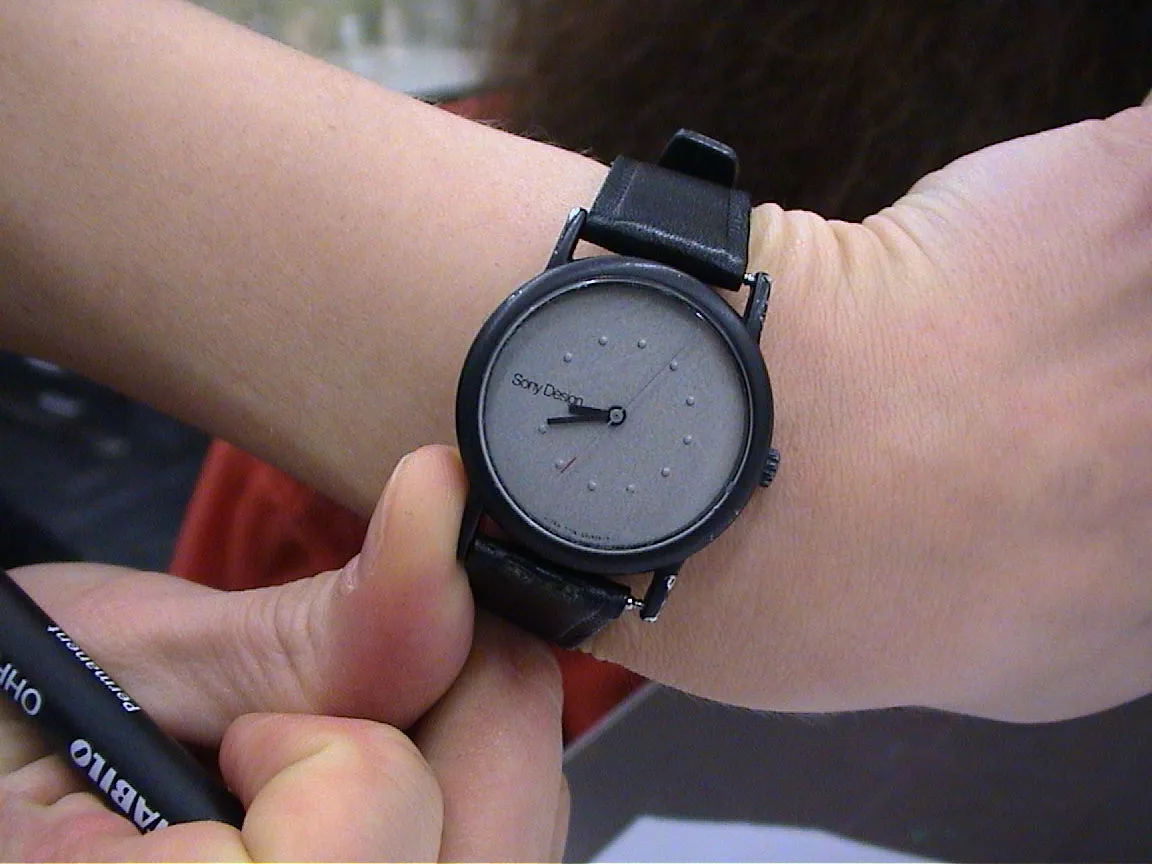 A black wrist watch shows it is nineteen to nine.