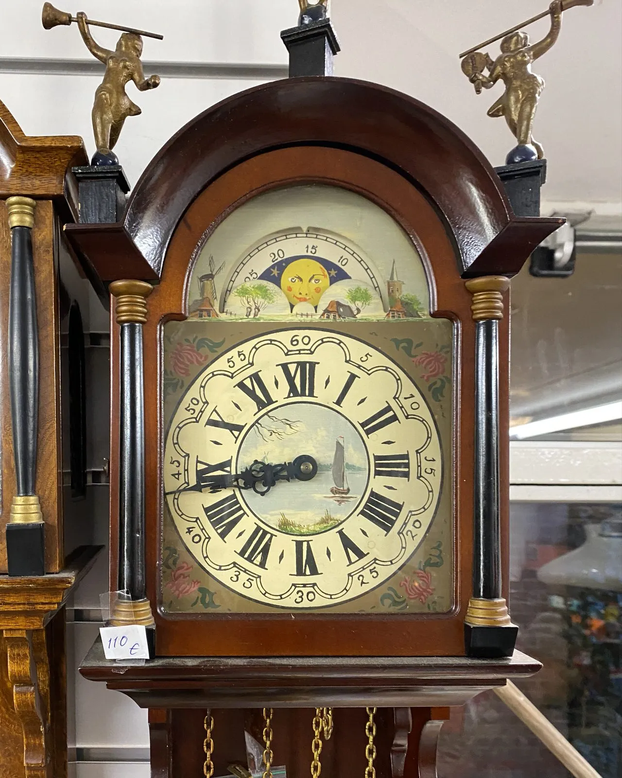 An old clock, with windmills on its face, points at 17 minutes to nine.