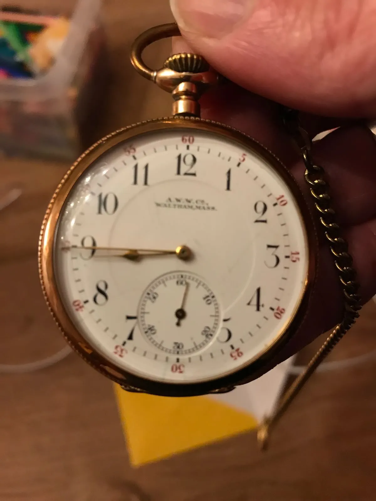 An old gold watch that points at a quarter to nine.