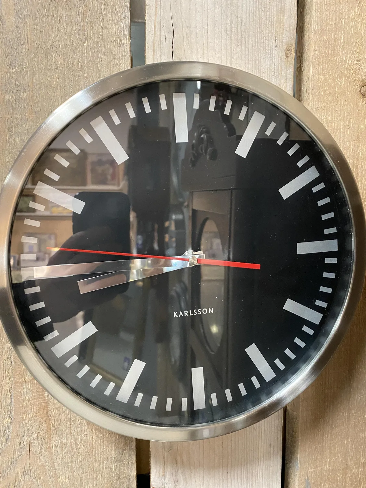 A black with silver clock. The hands point at a quarter to 9.