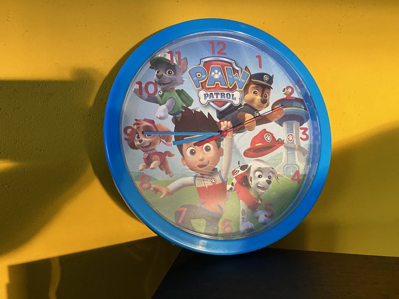 A children’s clock with an illustration of Paw Patrol on it. It points at a quarter to nine.