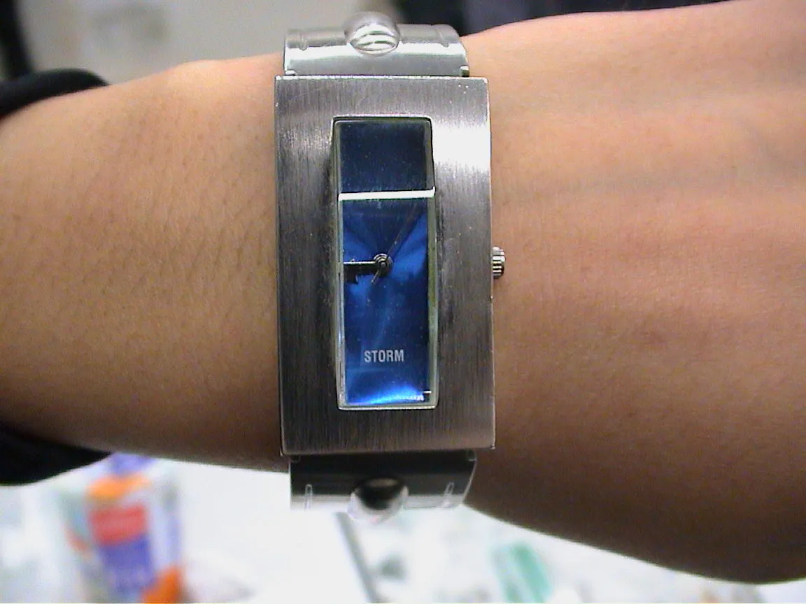 A very rectangular wrist watch points at fourteen to nine.