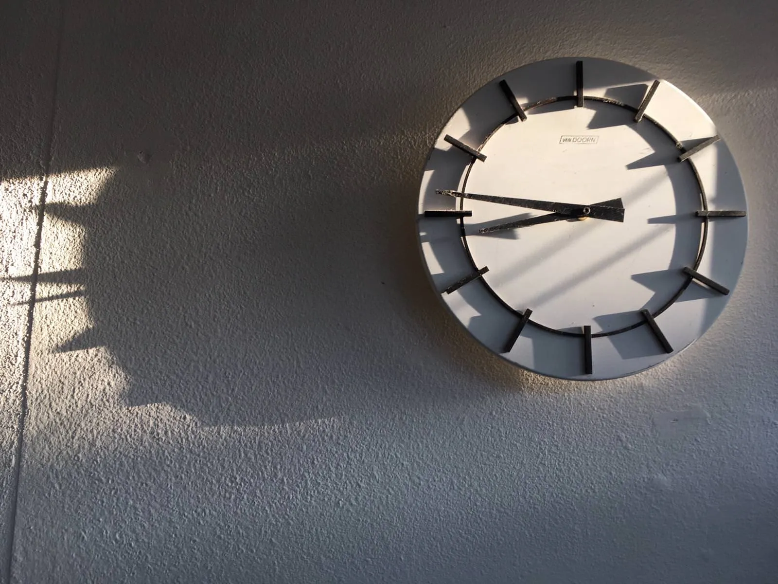 This geometric clock casts long shadows. It points at 14 to nine.
