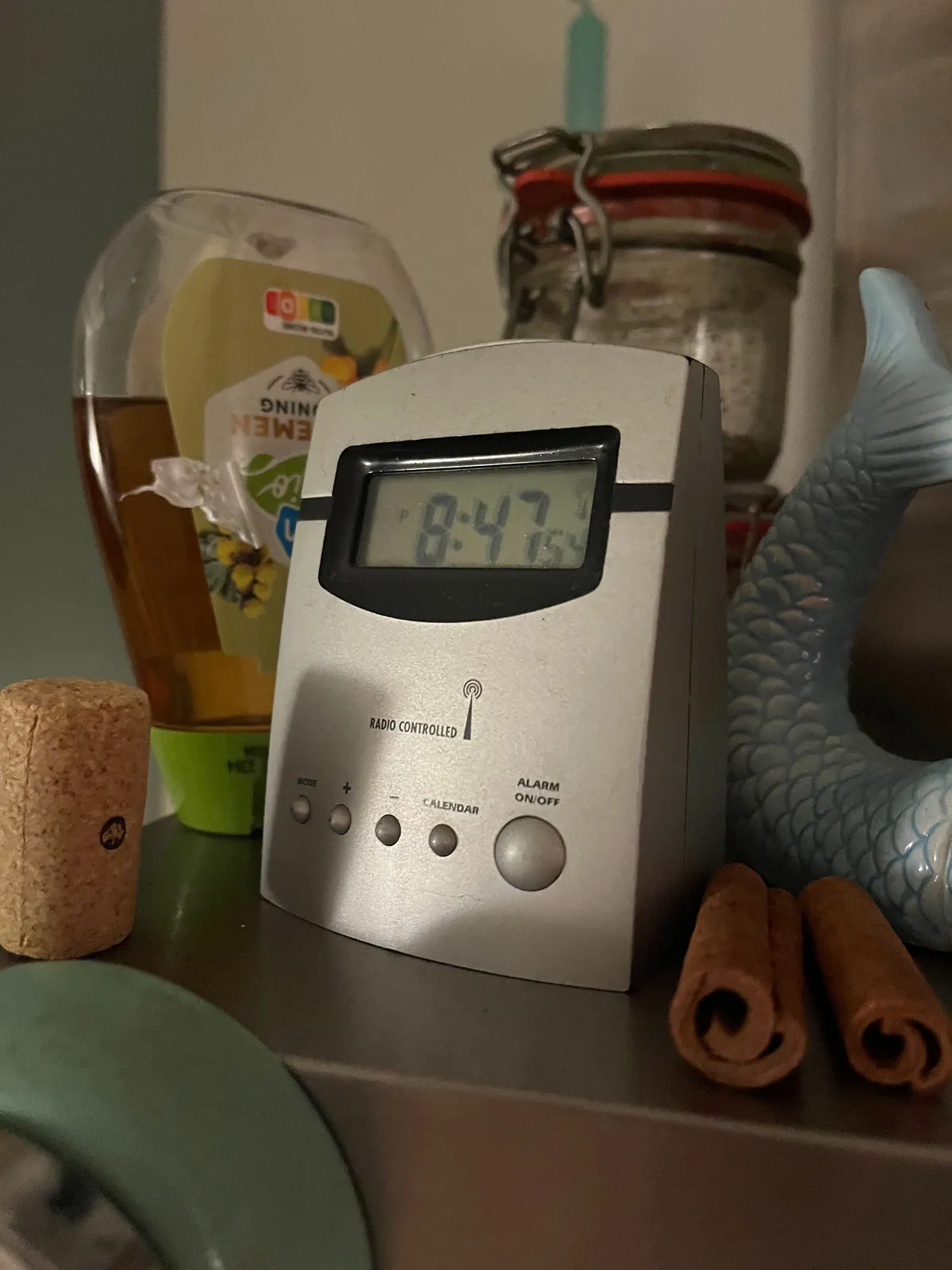 A small, digital radio controlled alarm clock. It says the time is 13 minutes to 8.
