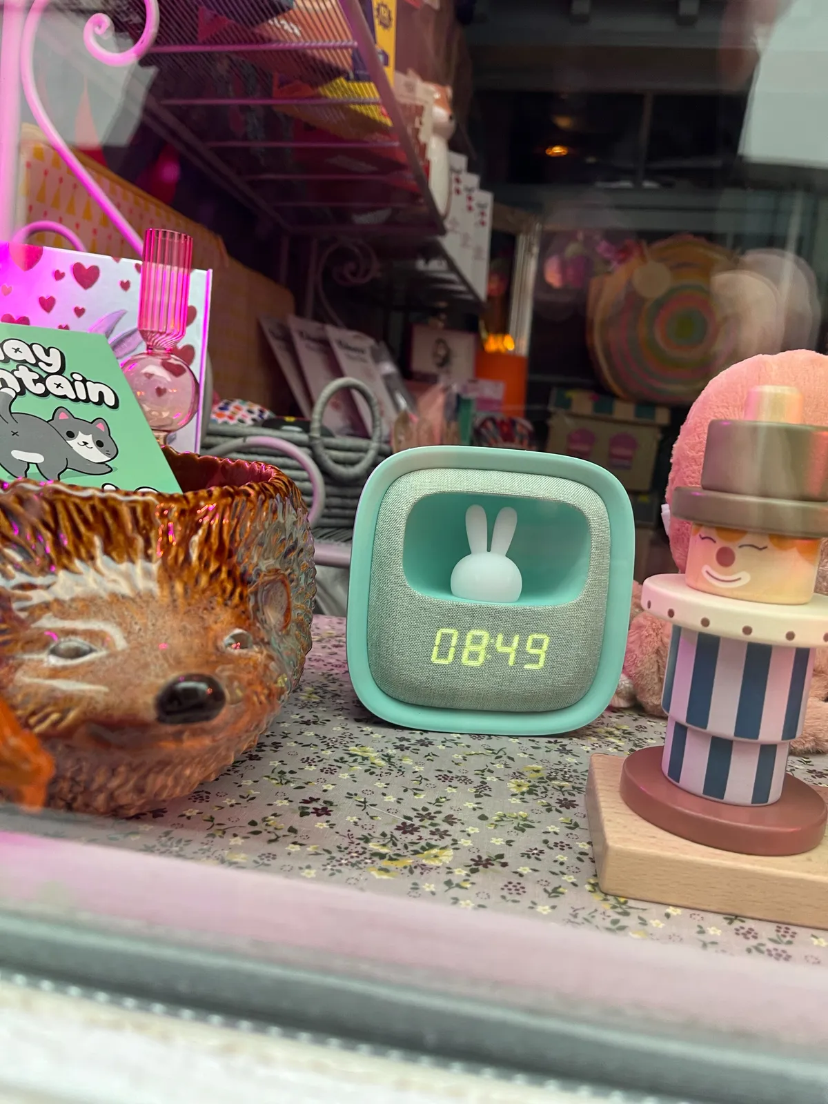In a gift shop window there’s a soft blue digital clock with rabbit’s ears. It prints the time as 08:49.