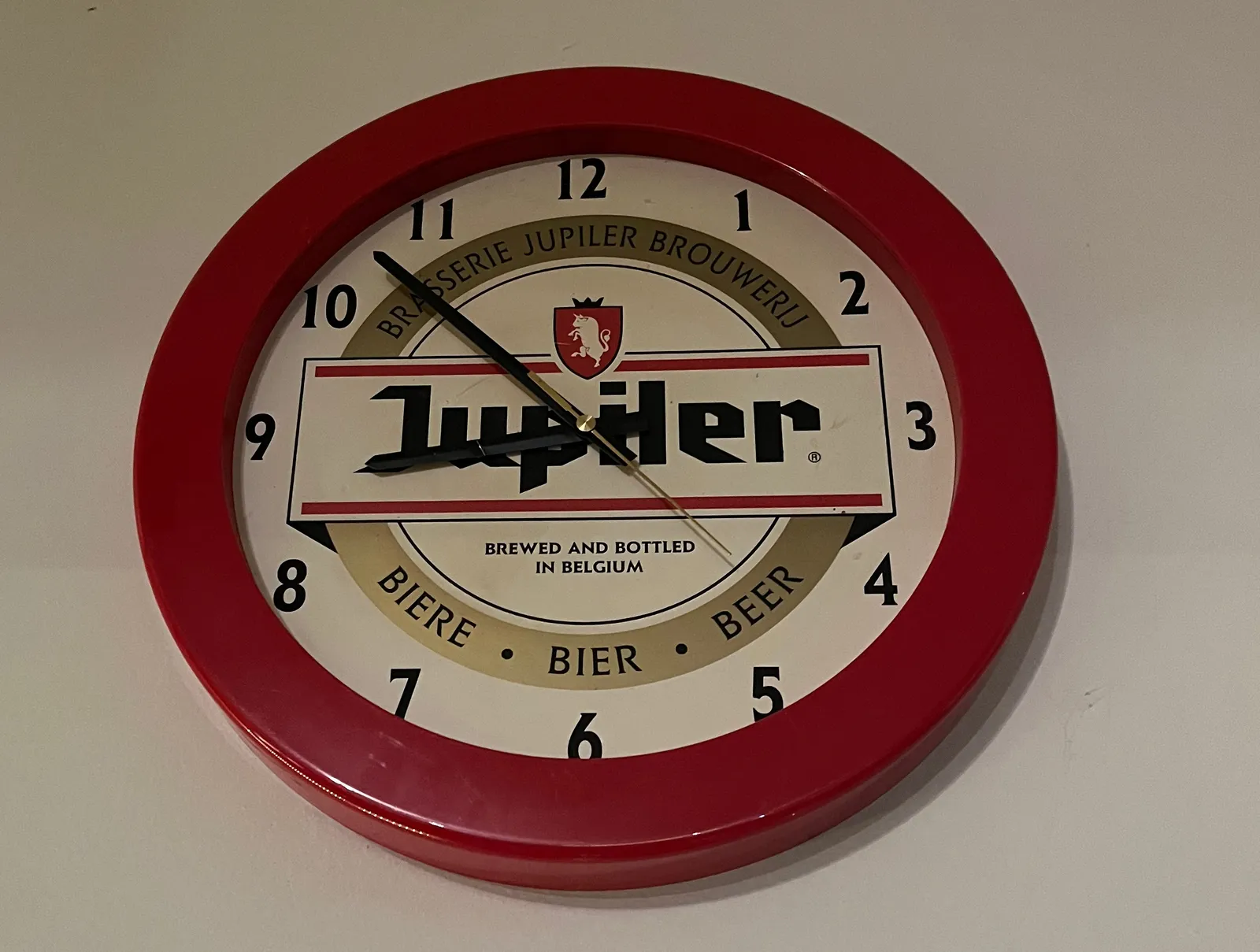 A Jupiler Beer clock points at eight to nine.