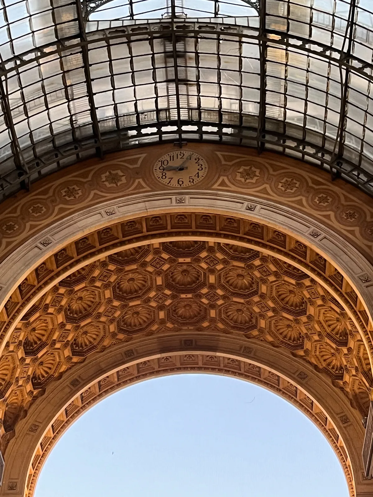 A richly ornamented arch with a clock built into it. It points at 5 past 9.