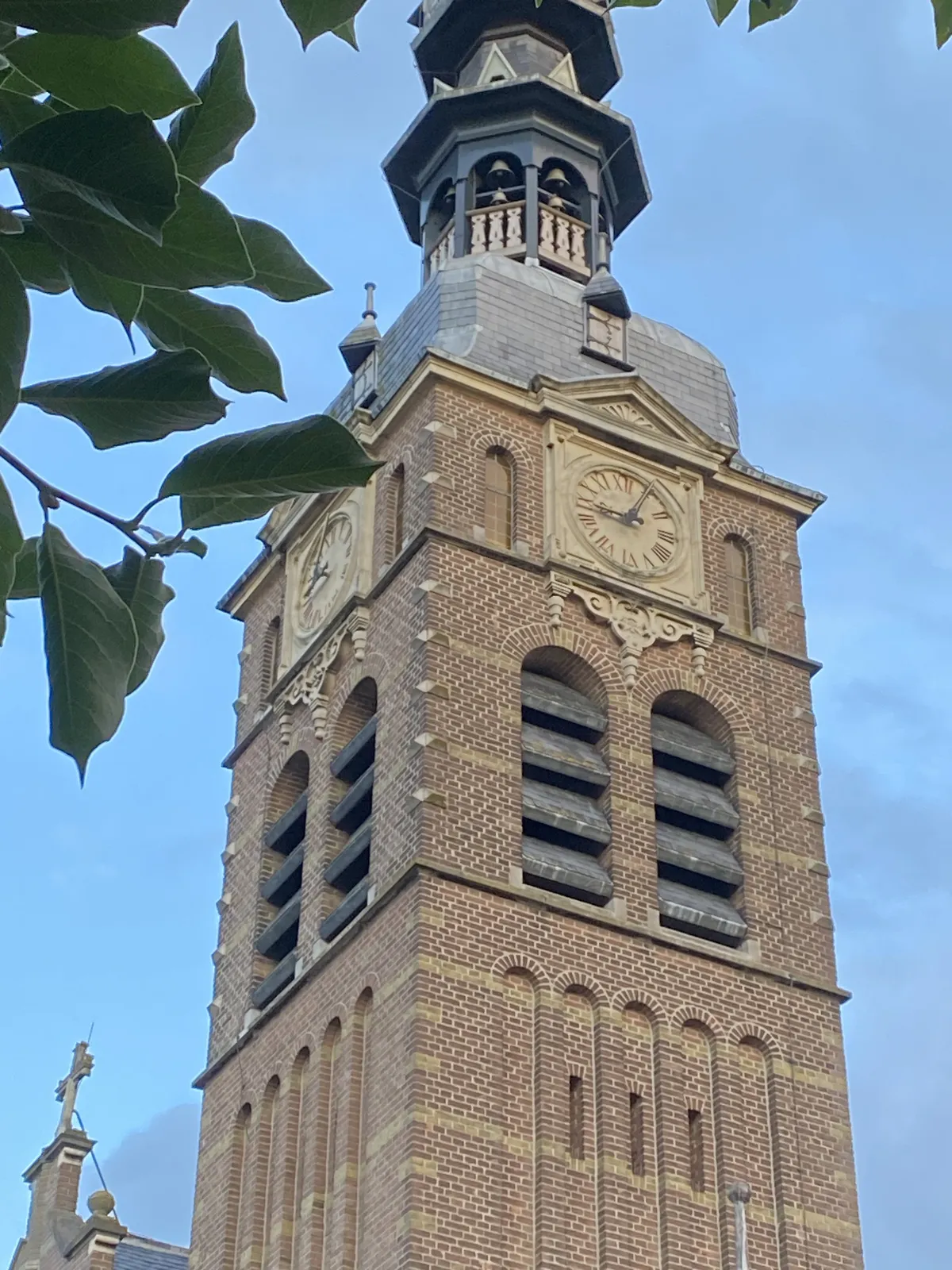 The clock on this church tower in Beek Ubbergen points at 6 past 9.