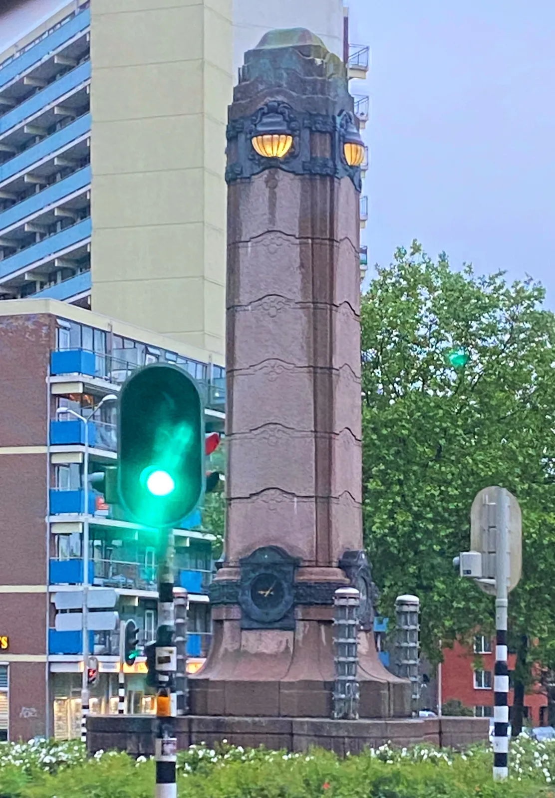A rather large phallic shaped thing in a city. There’s a clock on this thing which points at 7 minutes past 9.