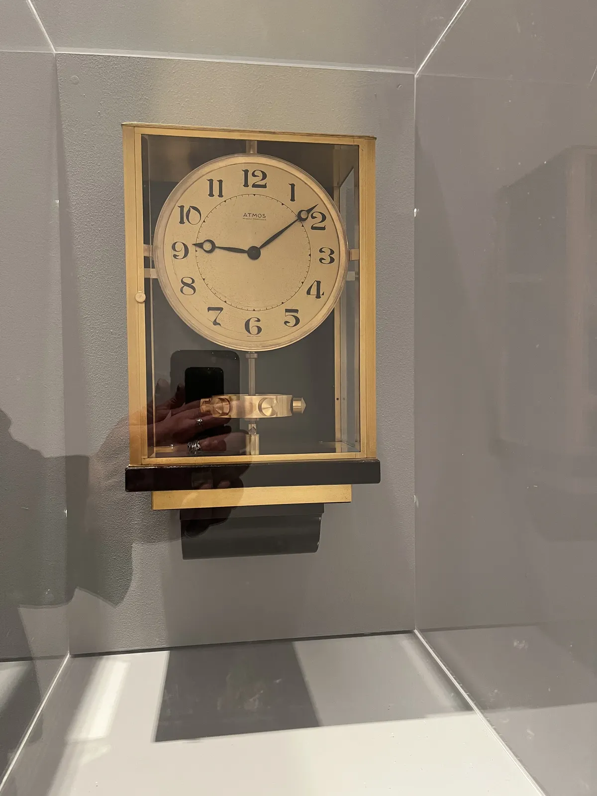 A clock in a brass frame. It points at 8 minutes past nine.