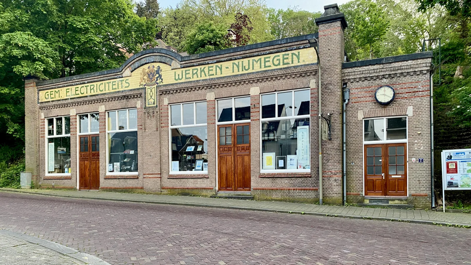 On an old building it says Gem. Electriciteits Werken Nijmegen, which translates to municipal electricity works Nijmegen. There’s also a clock on this building which points at 20 past 9.