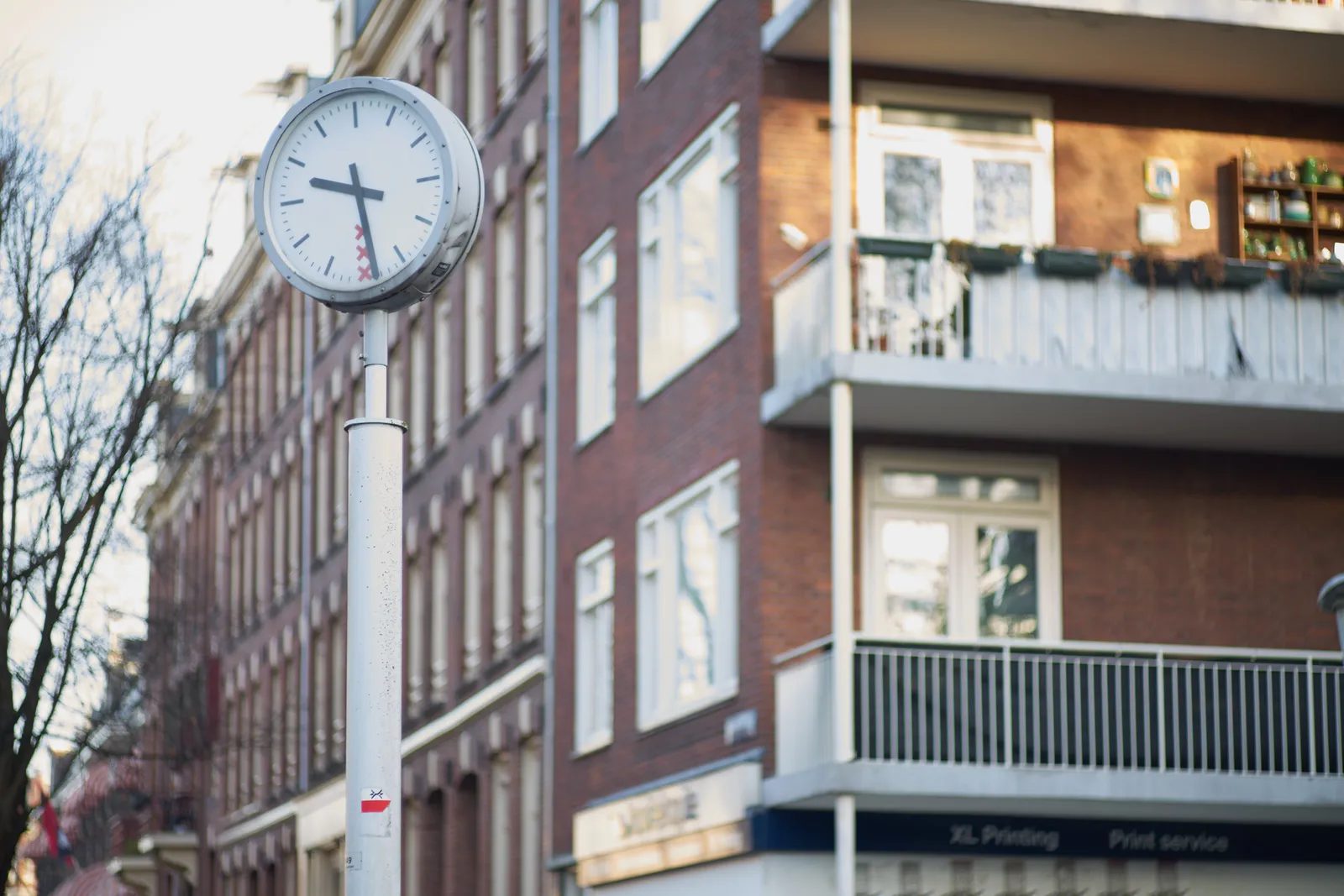 This clock on the streets of Amsterdam is pointing at 28 minutes past nine.