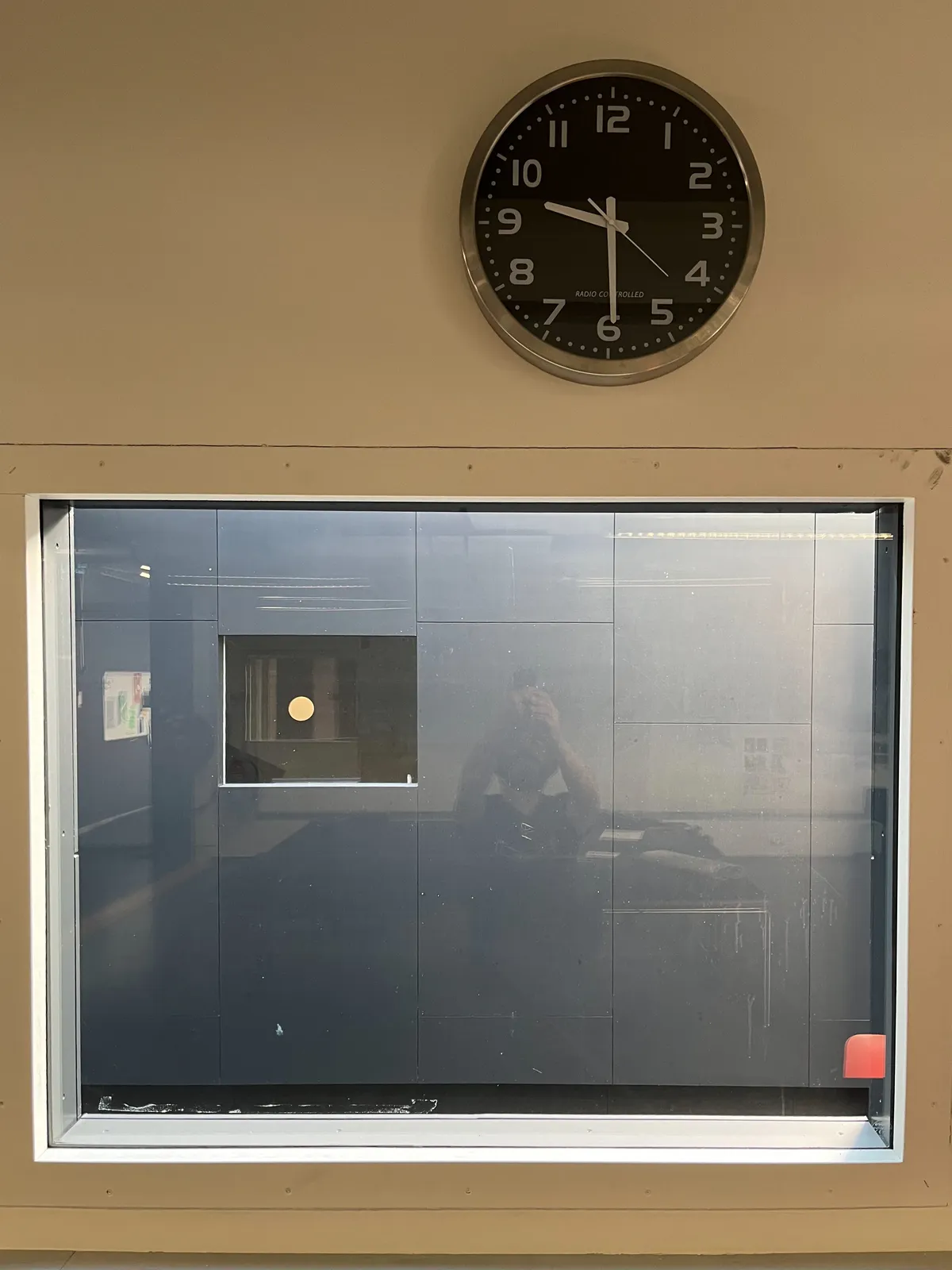 Peeking through a window at another window. Not much to through the window, there is a reflection of the photographer though. Above the window there’s a clock which points at 29 minutes past 9.