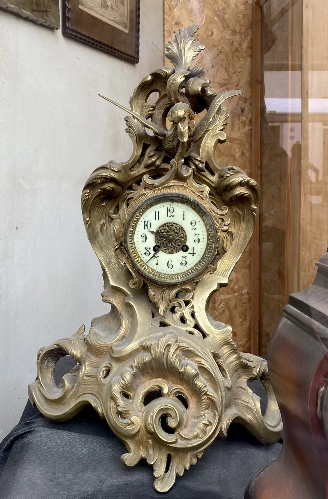 A rather expressive, old, sculptured mantel clock. It points at 37 minutes past 9.