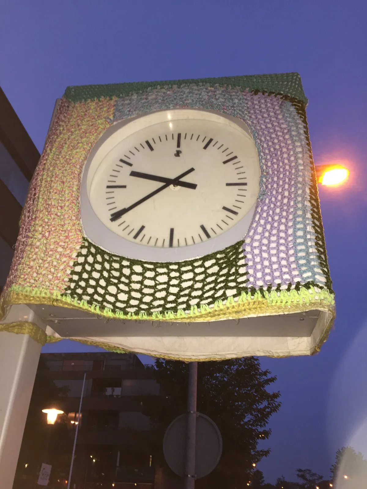Someone knitted a sweater for this clock. It points at 9:39.