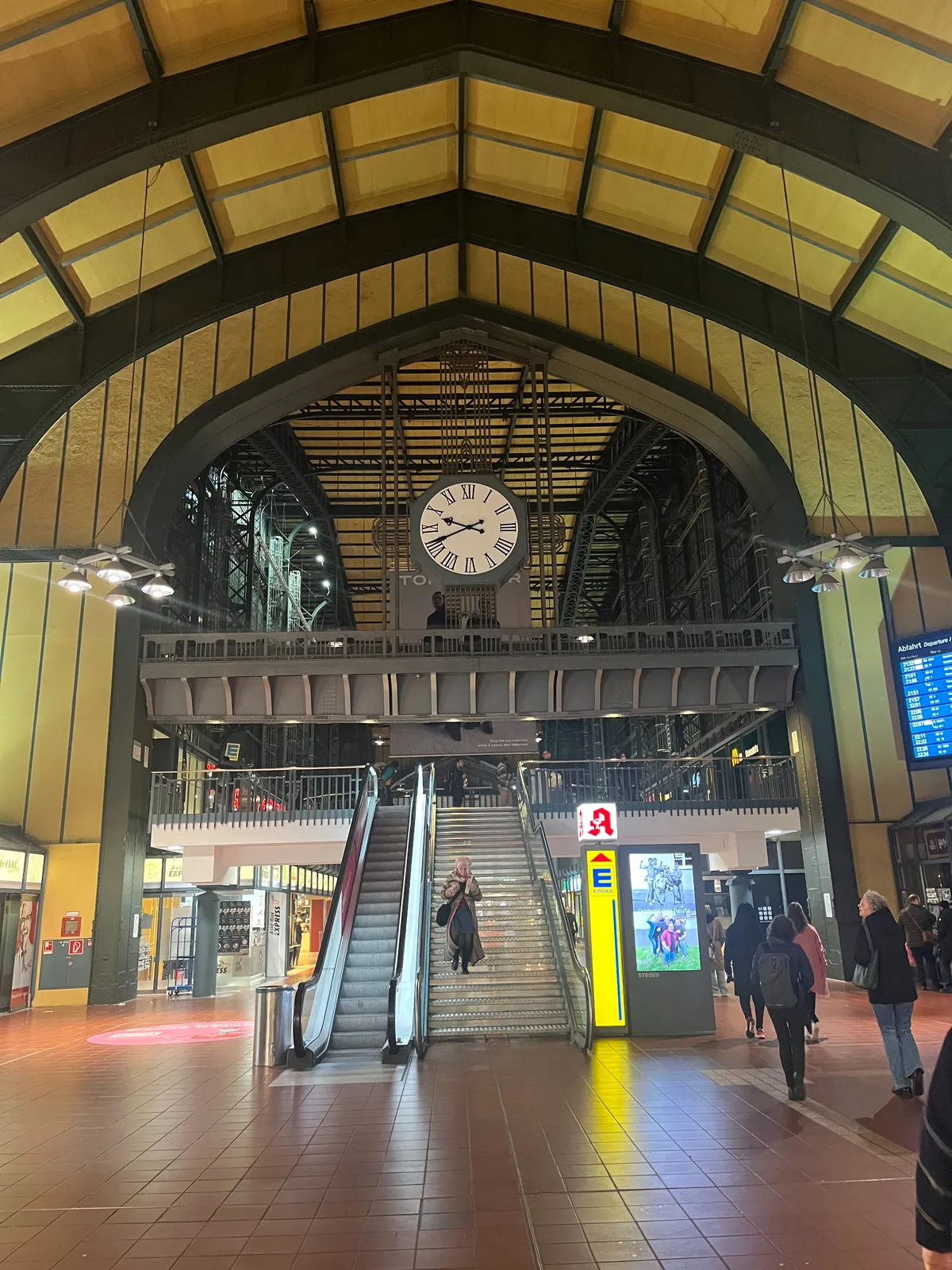 A large clock inside an enormous, old train station. It points at 19 minutes to 10.