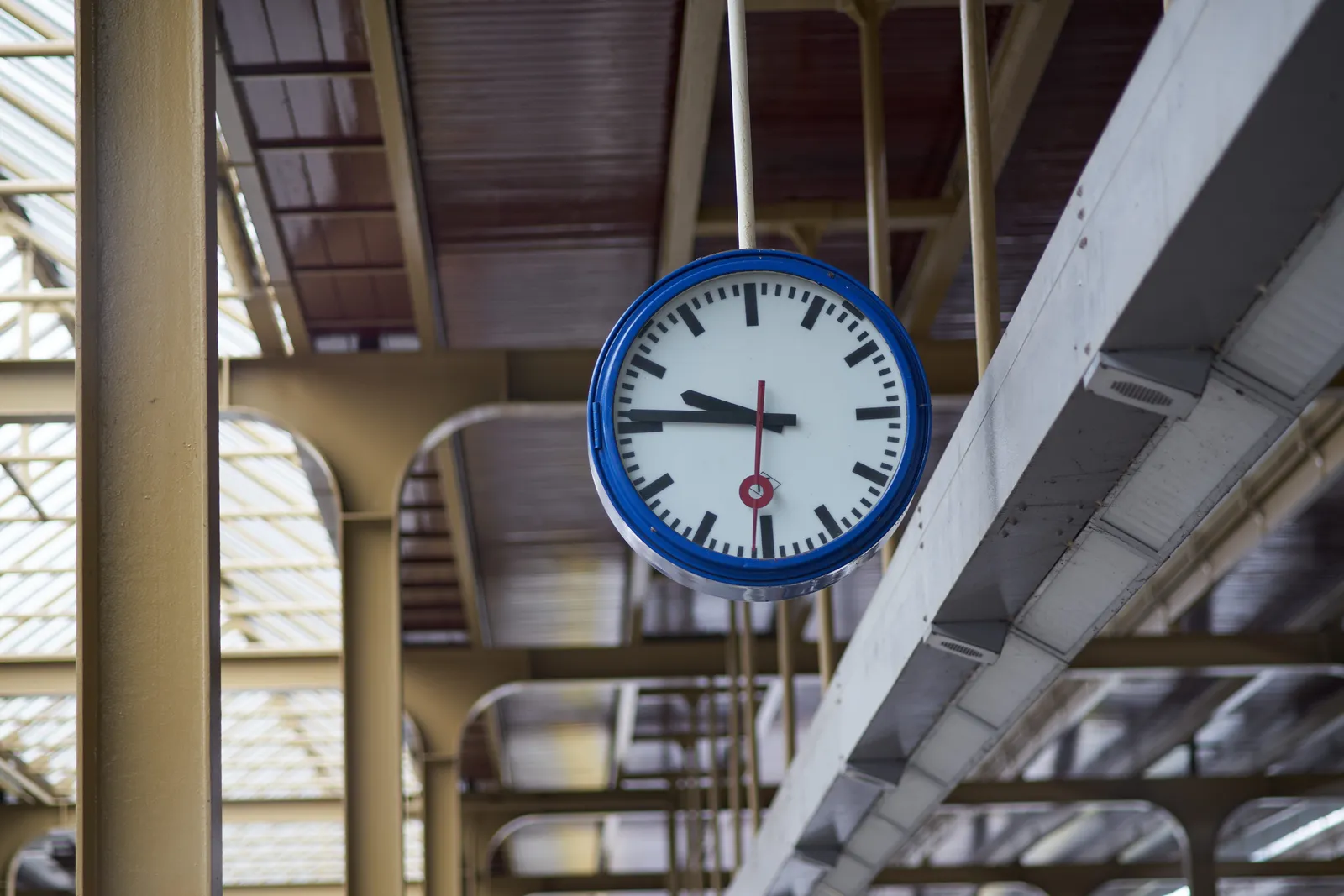 A clock on a train station points at 14 to ten.