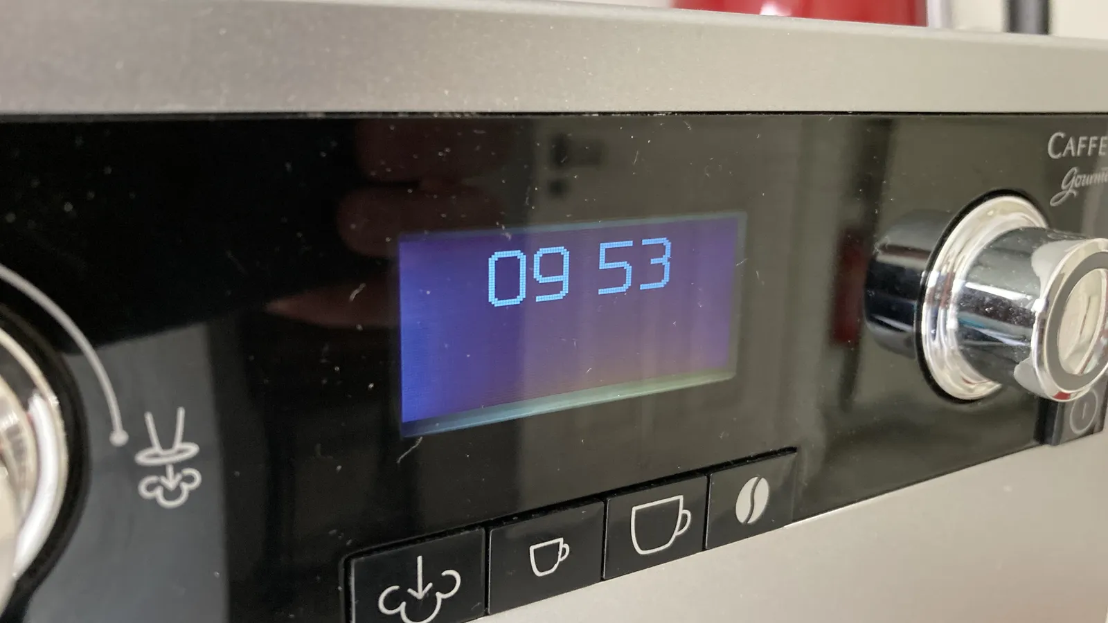 A coffee machine with a digital display that shows the time as 09:53.