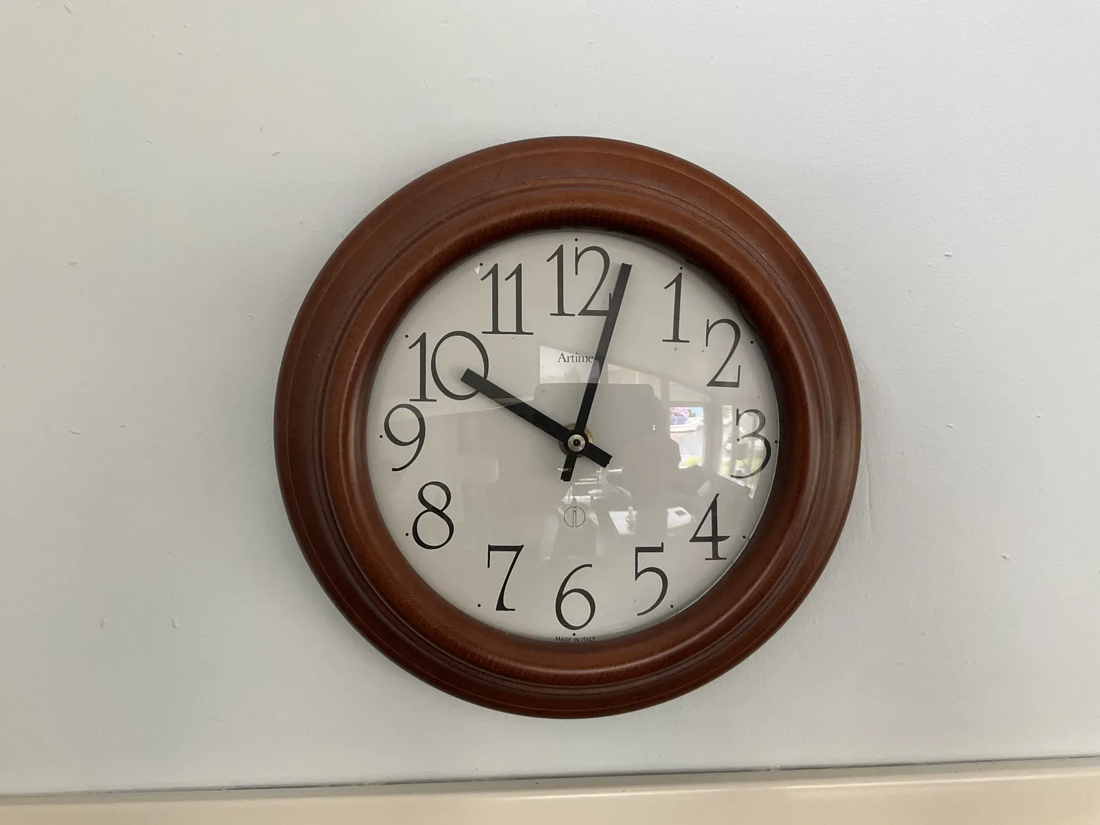 A wall clock. It points at 2 minutes past 10.