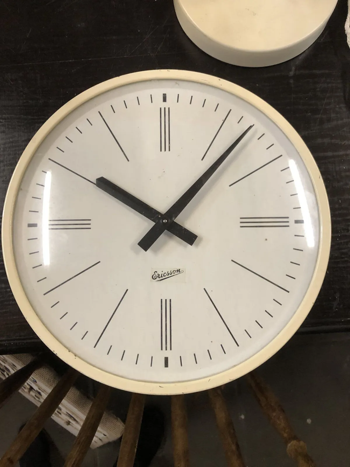 A simple white clock with black hands points at 7 past 10.