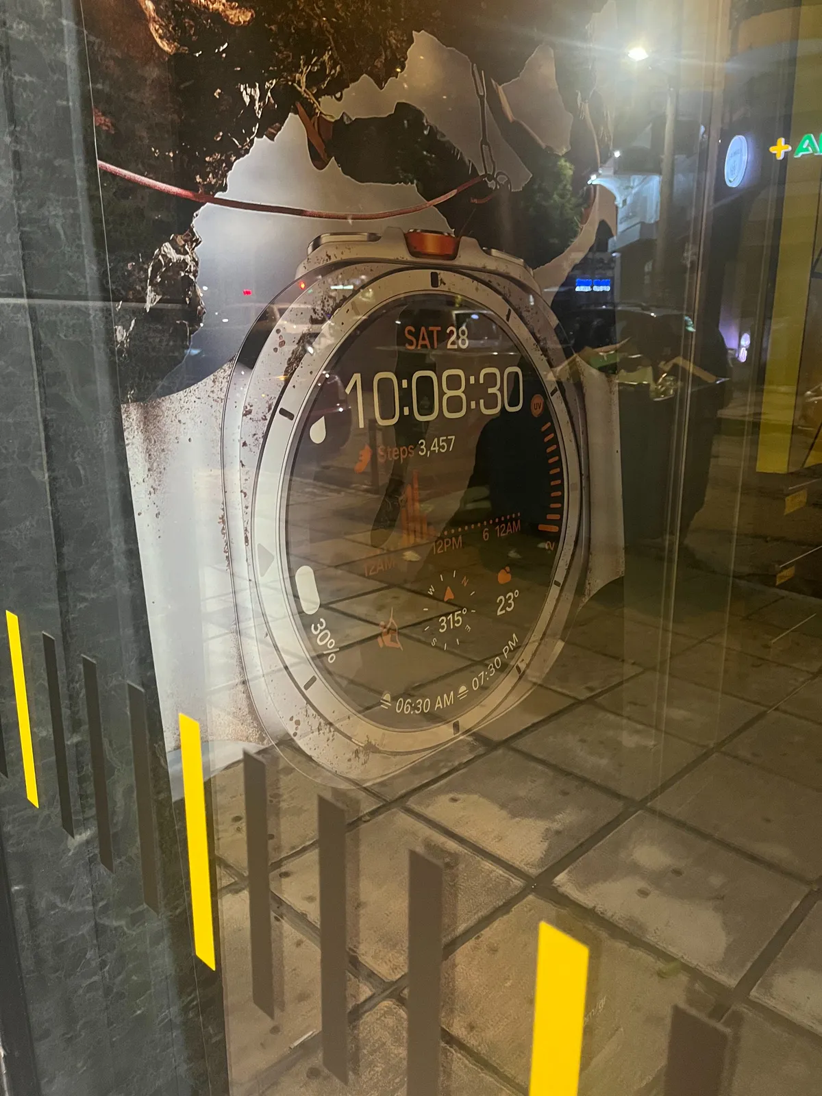 Peeking through a window at an advertisement of a very complicated watch. It displays the time as 10:08:30