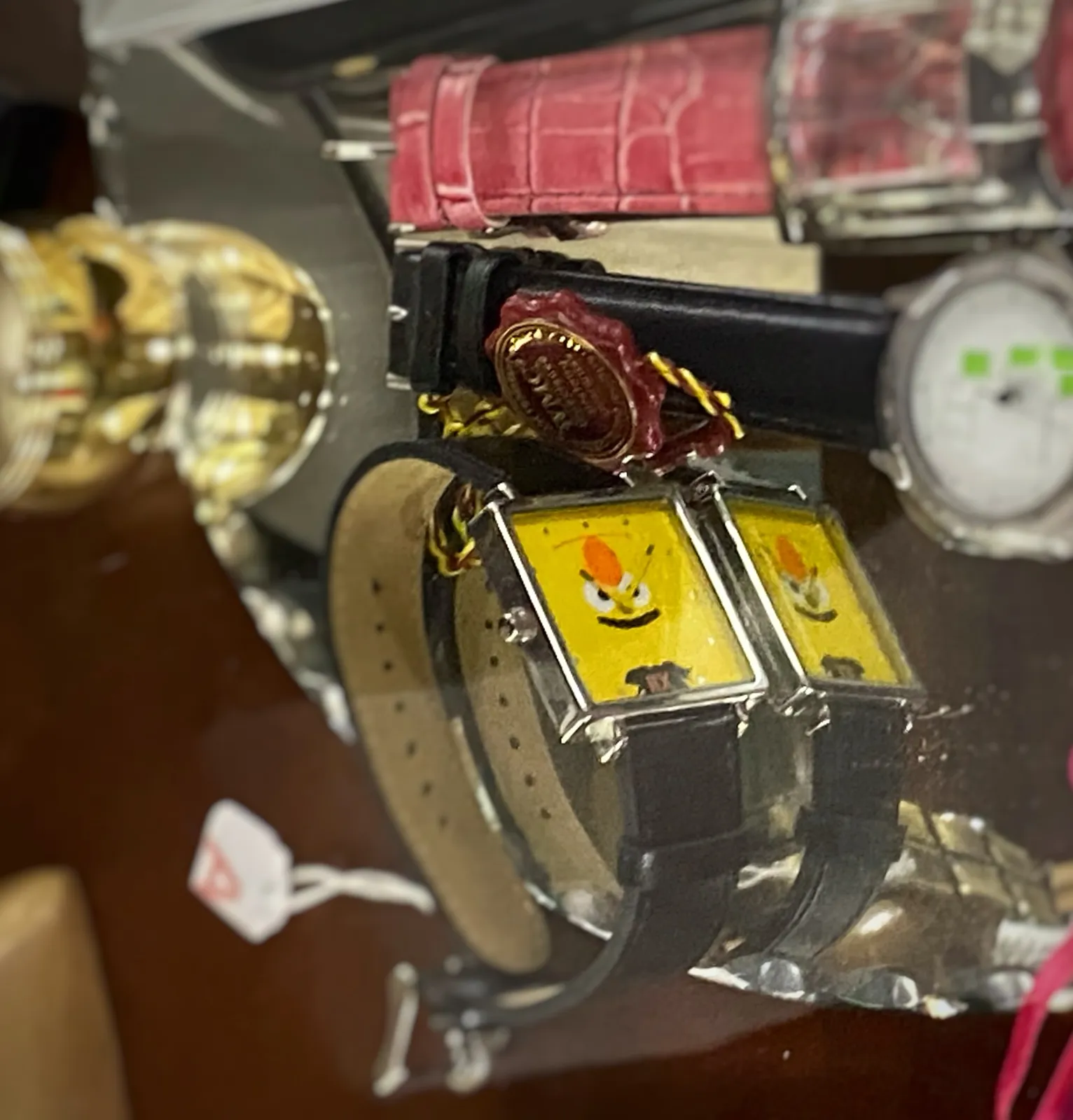 A yellow wrist watch with … a face on its face. The hands make it look a bit grumpy. It points at 8 past 10.