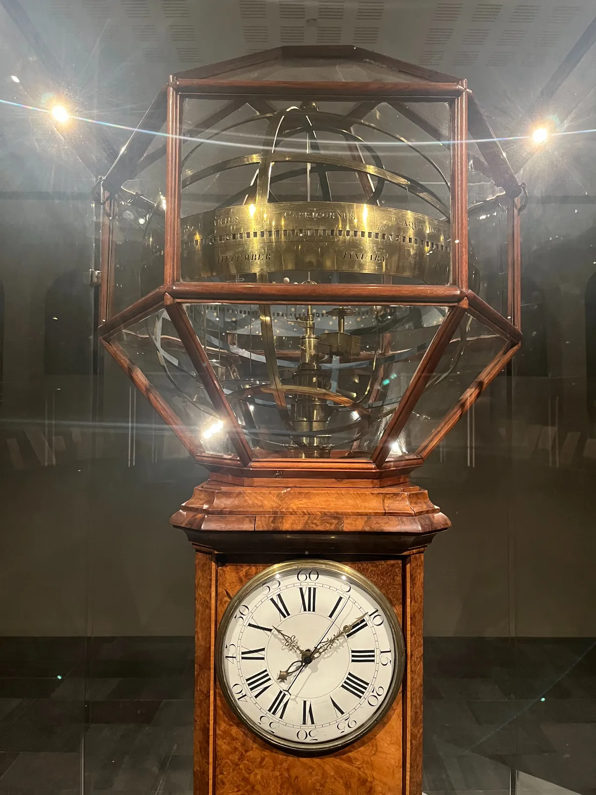 A very old mechanical clock, which seems to be able to show much more than only time. There’s a large complicated mechanical dome on top of it. But it also has a simple face with two hands that clearly indicate that it is 9 past 10.