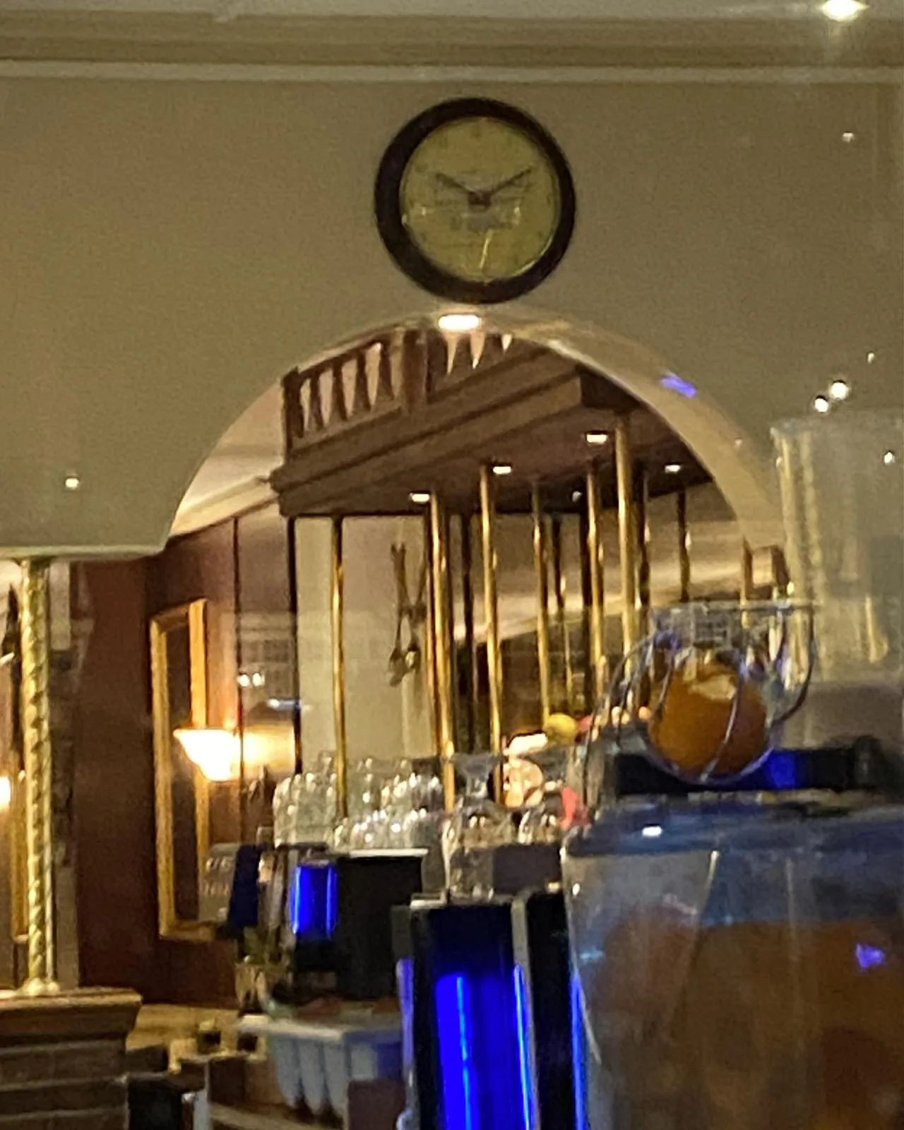 This clock hanging on the top of an arch in a bar points at ten past ten.