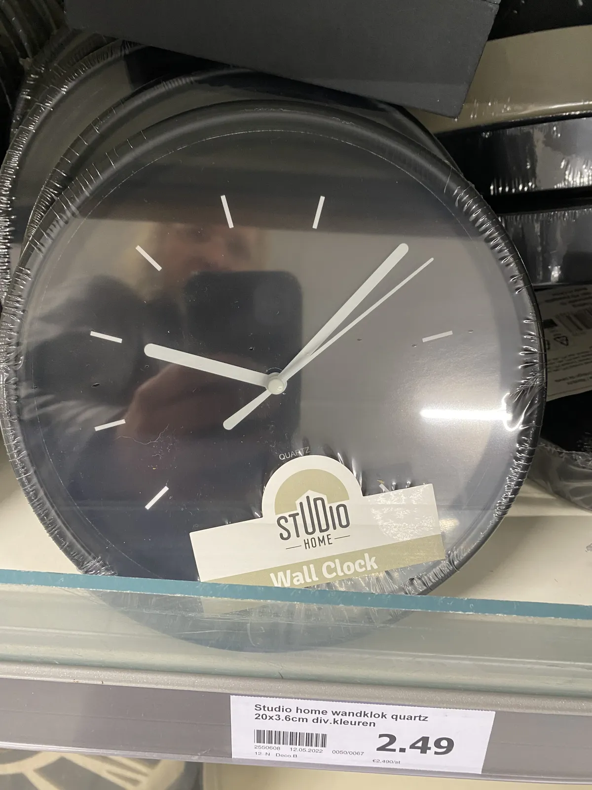 A black plastic clock is for sale for 2,49. It points at 10 past 10.
