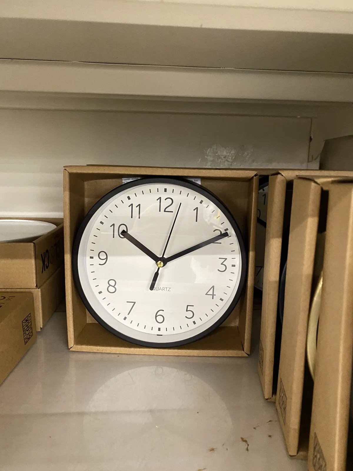 A clock in a box points at 10 past 10.
