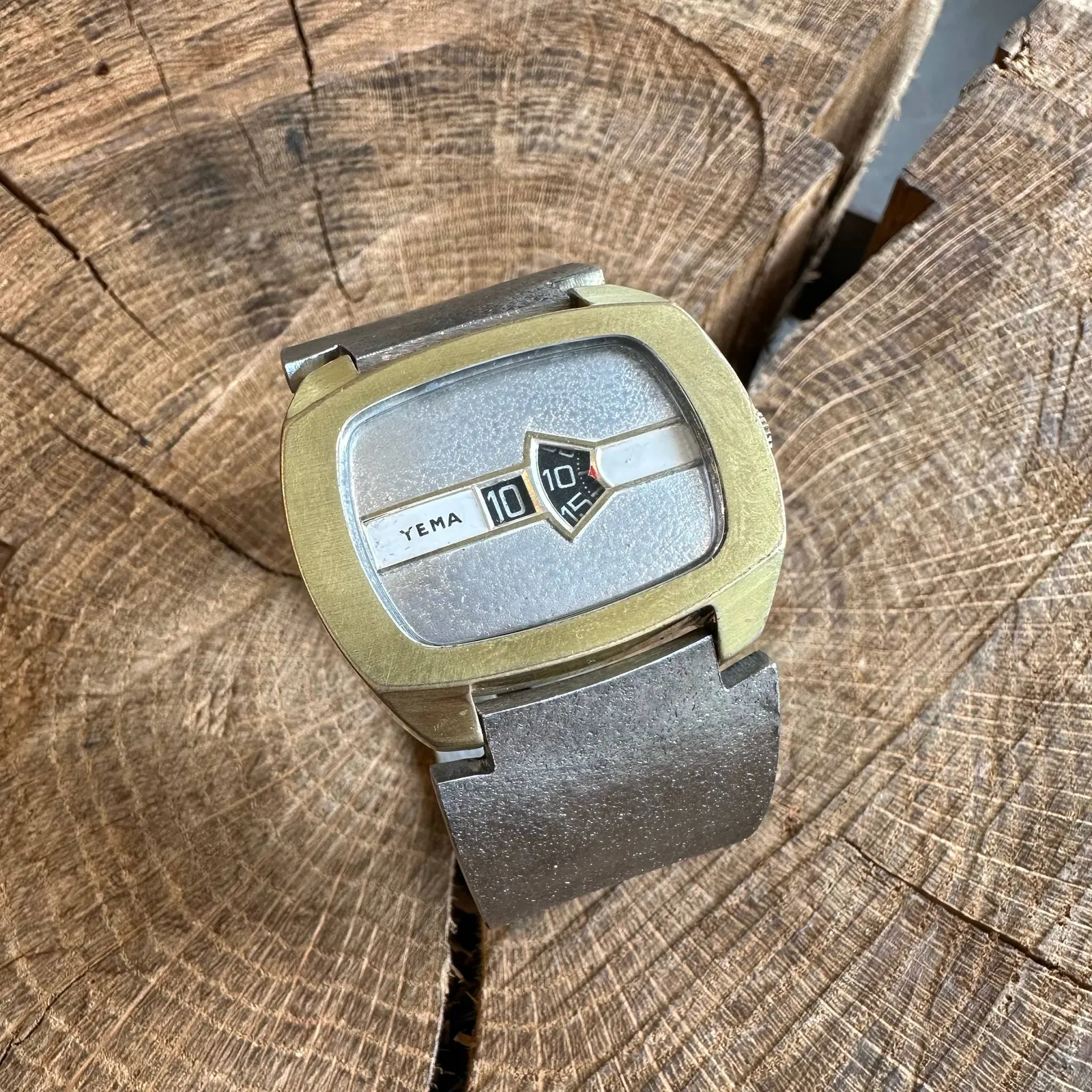 A very special, well designed, elegant, silver and gold, wrist watch. The time is not shown by hands, but by two mechanical dials underneath the face. They tell the time as 11 minutes past 10.