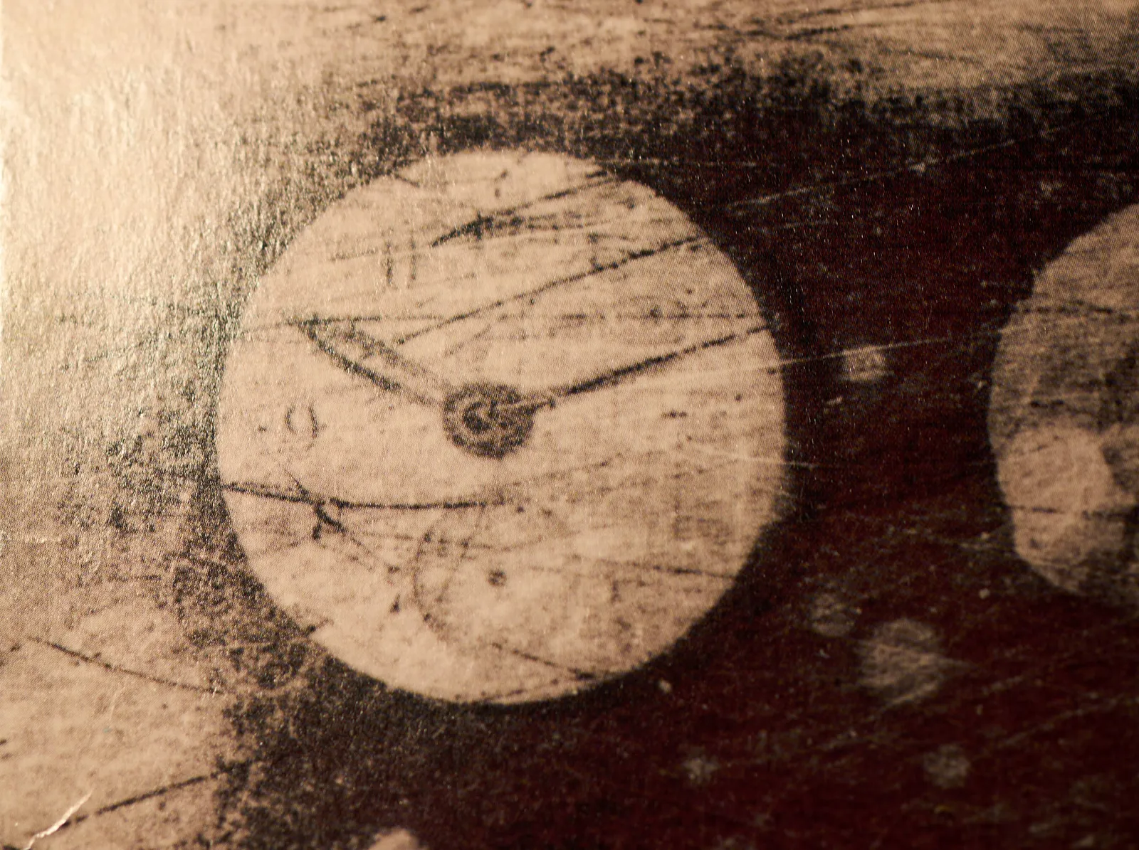 A detail from a Ministry album. A clock can be seen that points at 11 past 10.