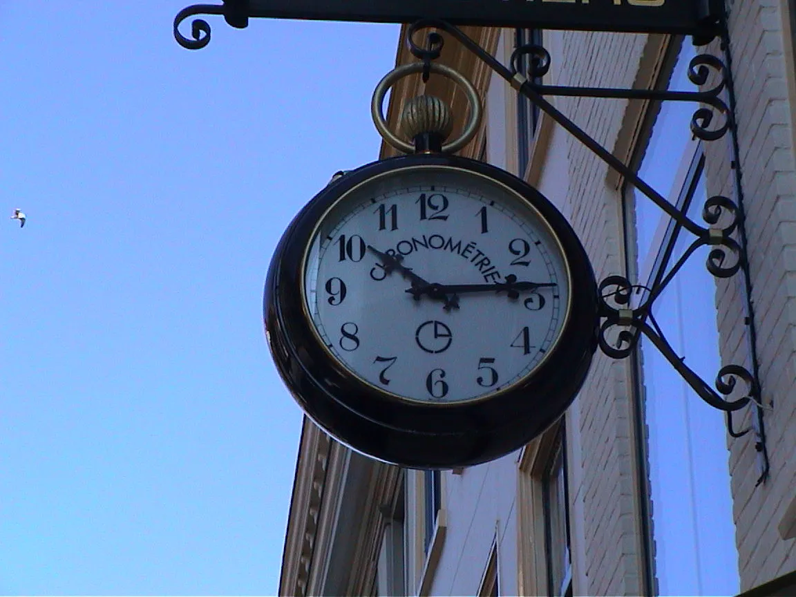 It is 10:14 on this clock, attached to a building. On it the word Chronométrie is printed.