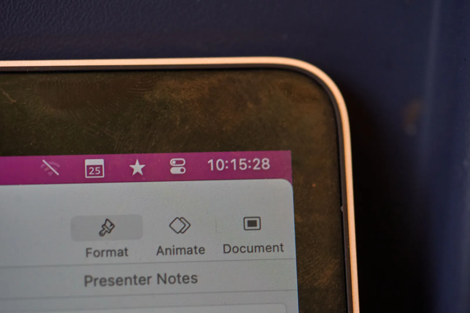 A foto of the corner of a laptop. Someone is making a presentation. The clock on the screen says it is a quarter past 10.