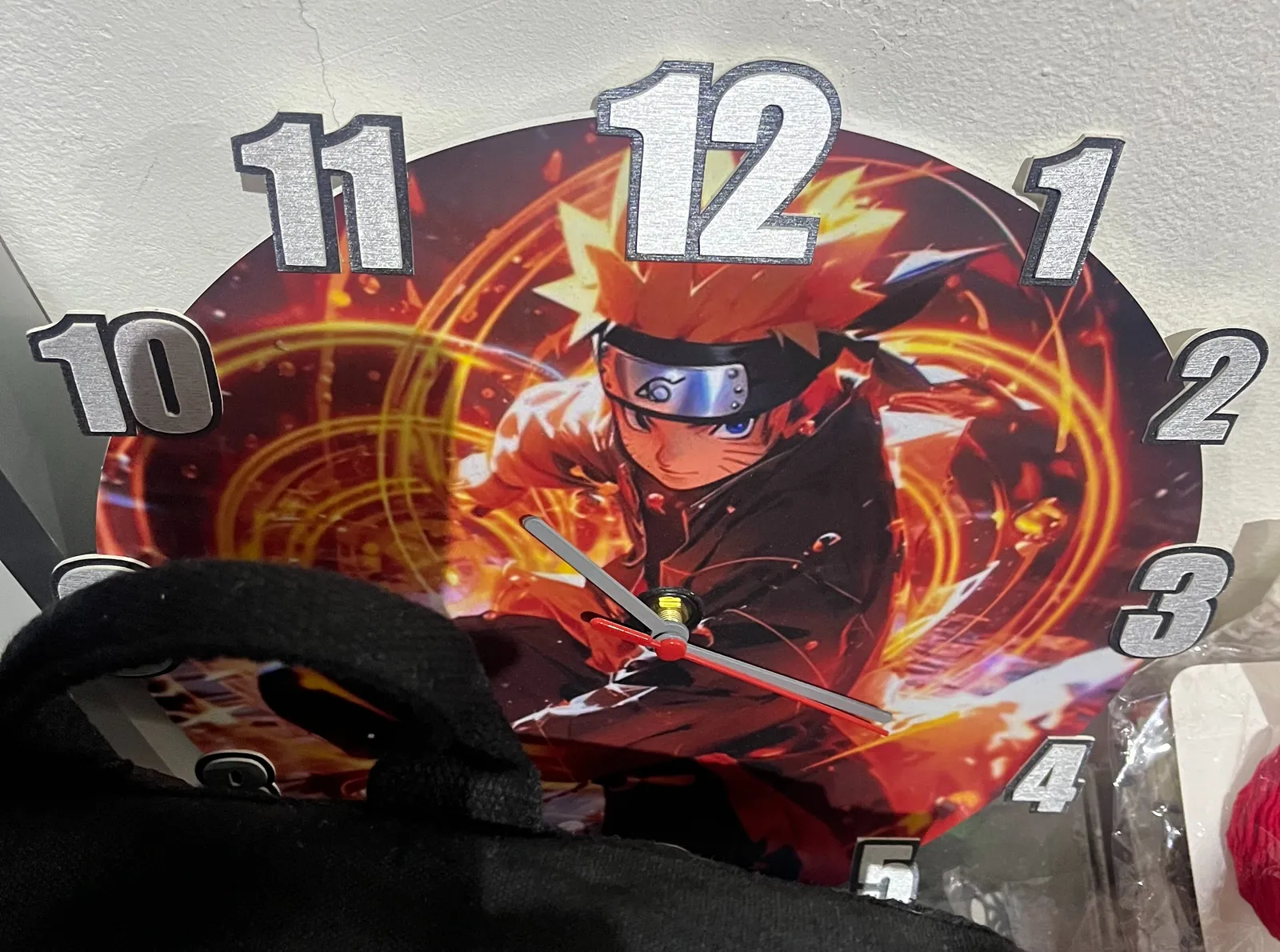 A clock with a japanese manga character on its face points roughly at 20 past 10.