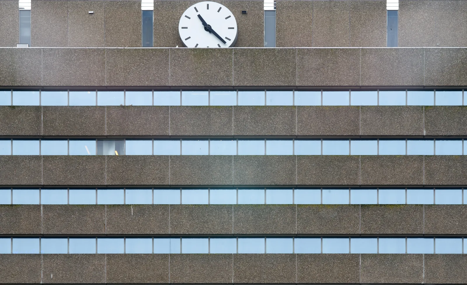 This enormous clock on top of an enormous concrete building points at 22 past 10.