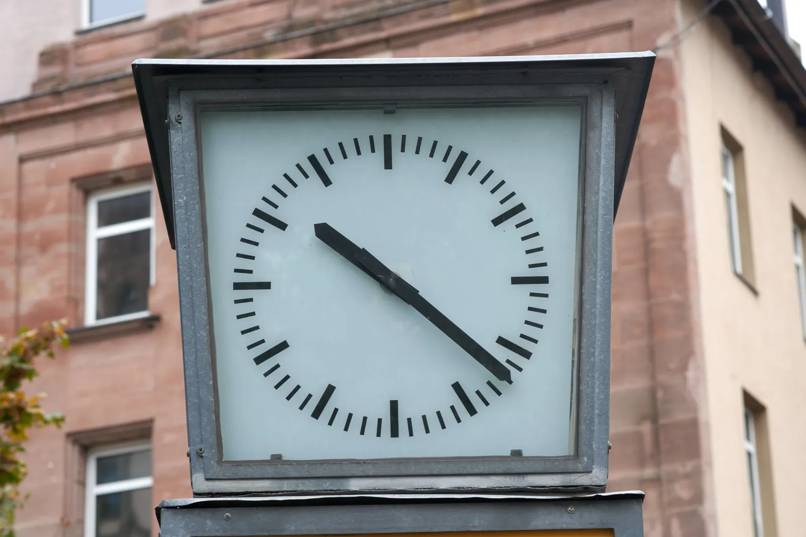 A modern clock in a simple metal frame. It points at 22 past 10.