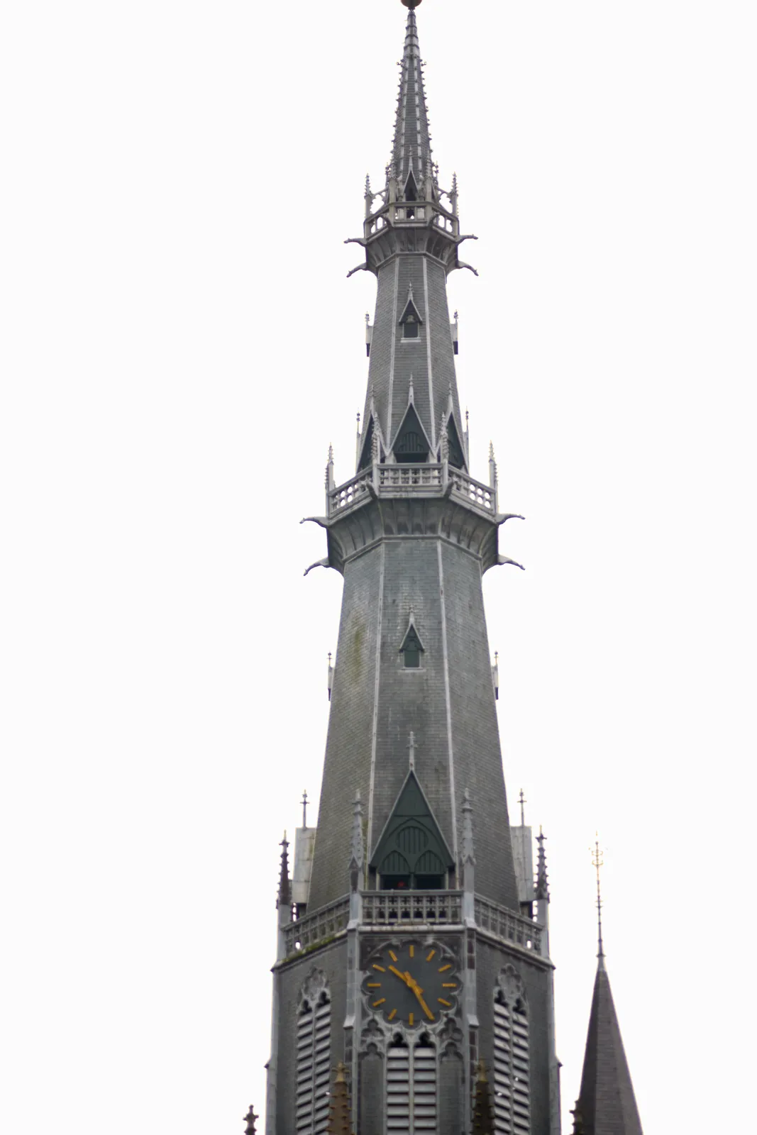 A pointy church tower points at 25 past ten.