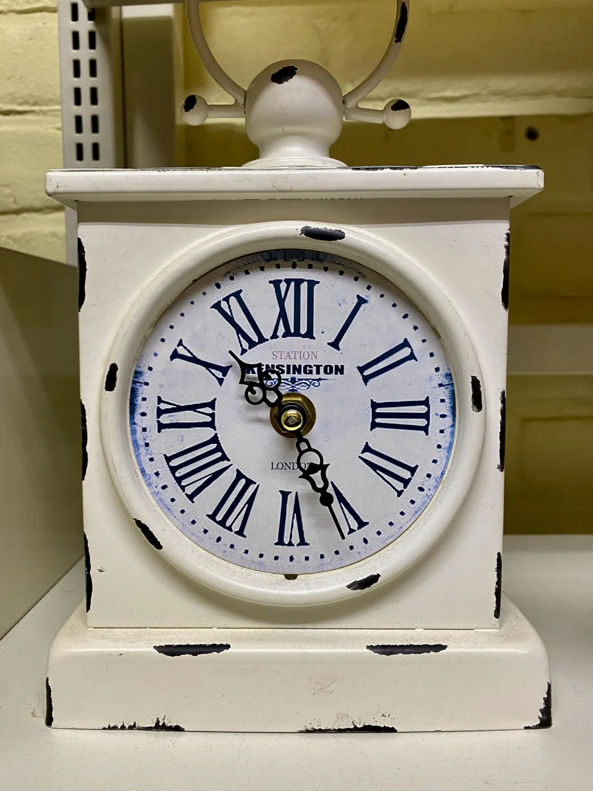 A table clock that is deliberately aged. It points at 26 past 10.
