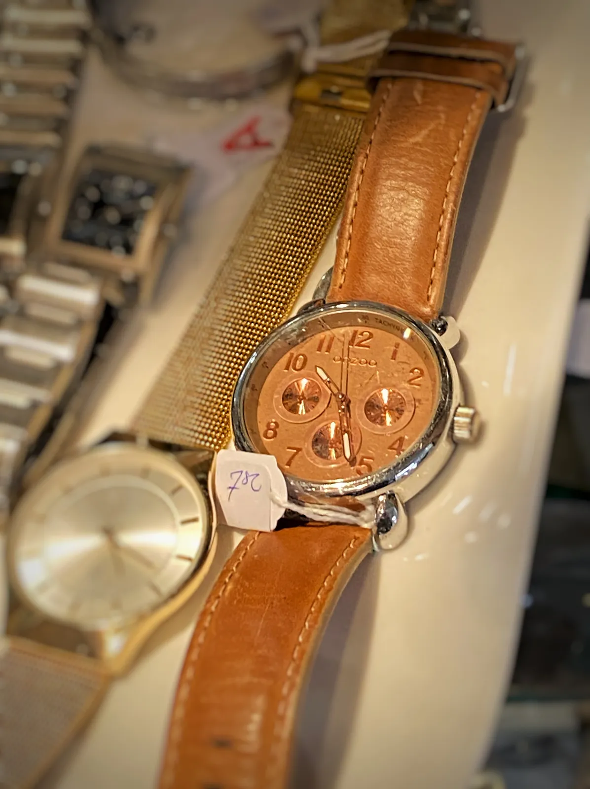 A few old watches on sale. On one of them the time can be seen. It points at 26 past 10.