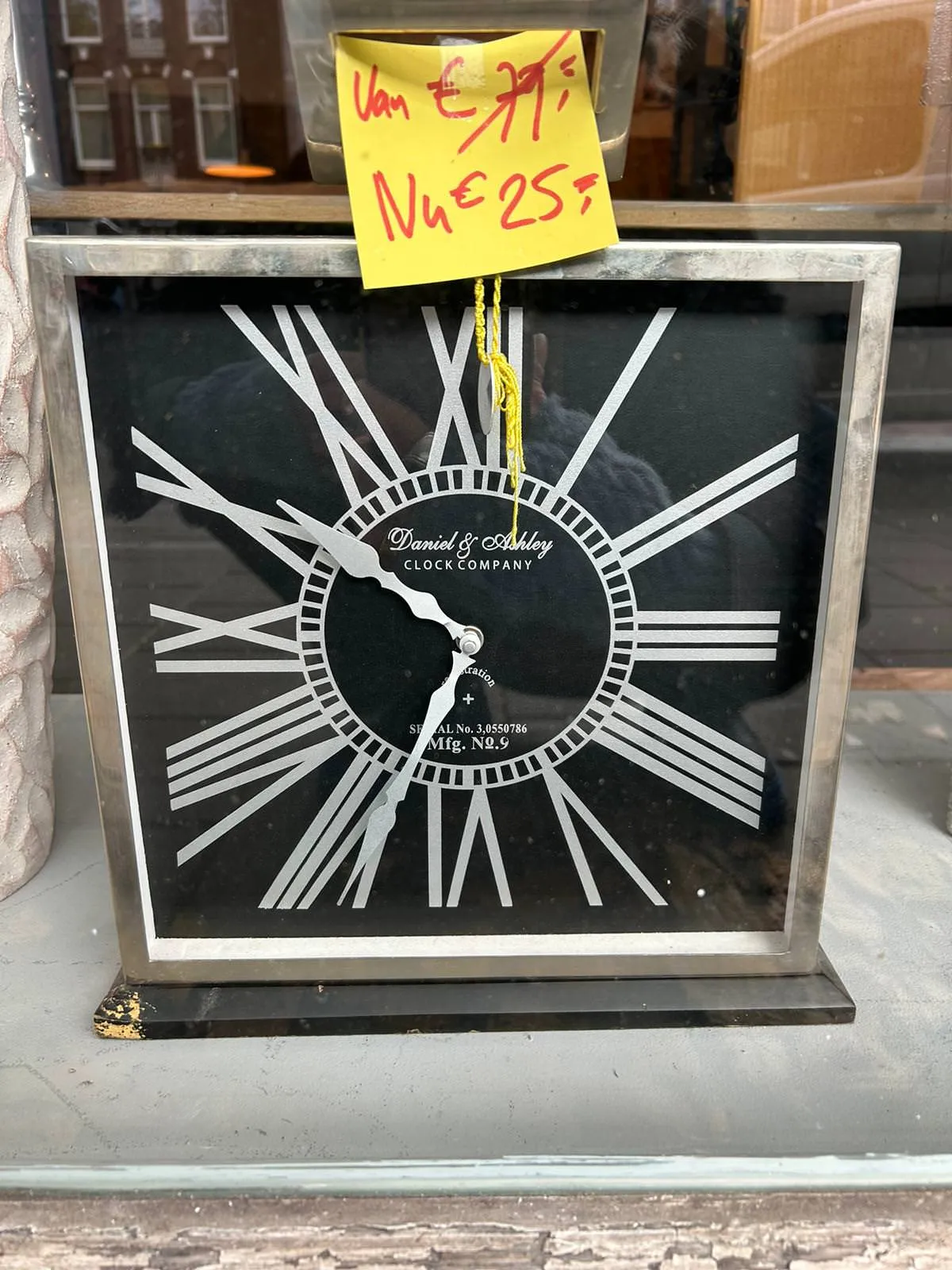 A clock for sale, with a nice discount. It hase very large, morphed roman numerals. It points at approximately 26 minutes to 11.