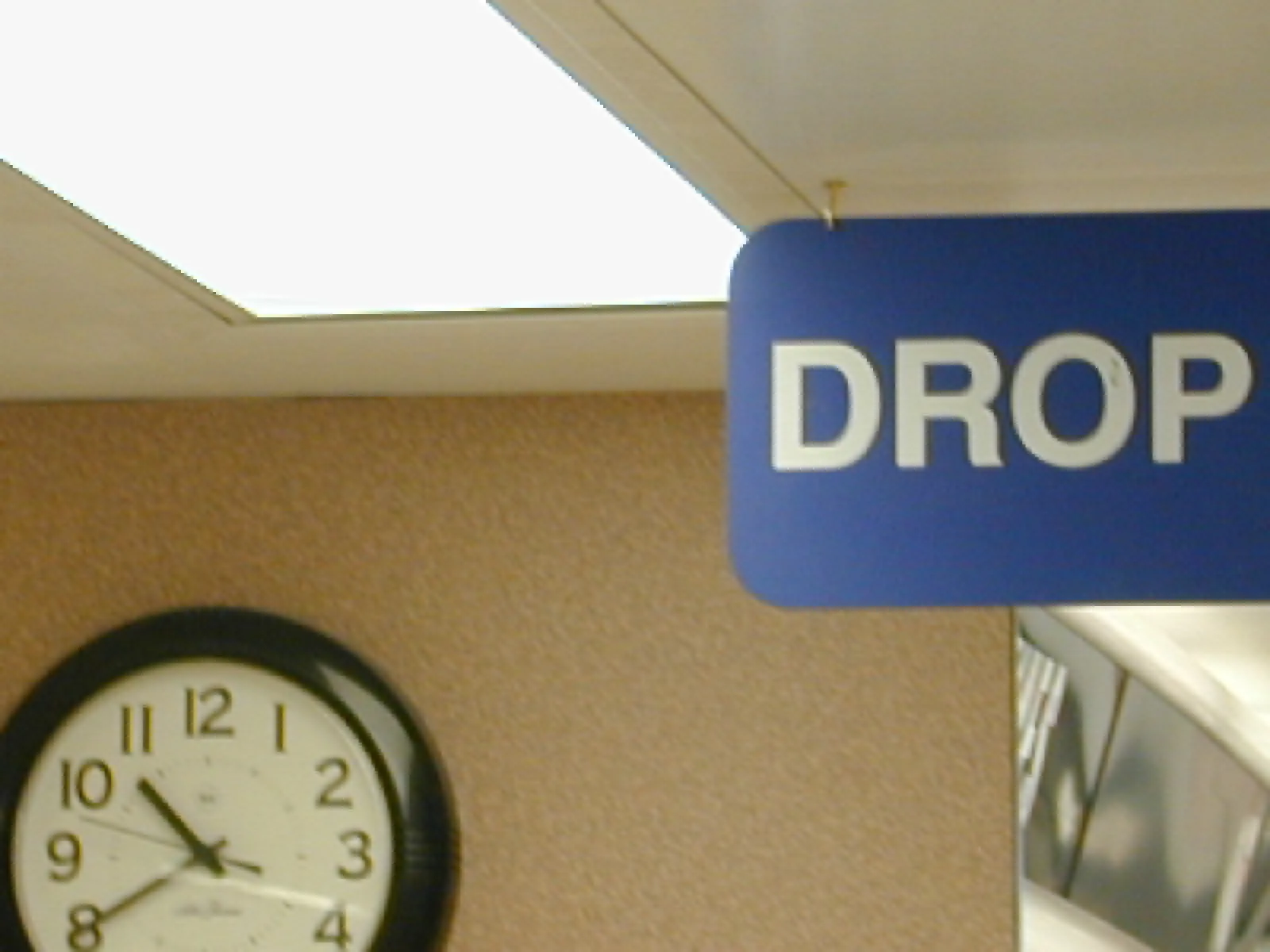 A clock next to a sign that says Drop, points at 40 past ten.