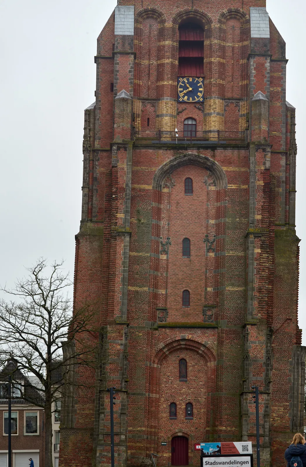 A very large, monutemtal chruch tower, slating a bit. On it is a clock. It points at 41 past ten.