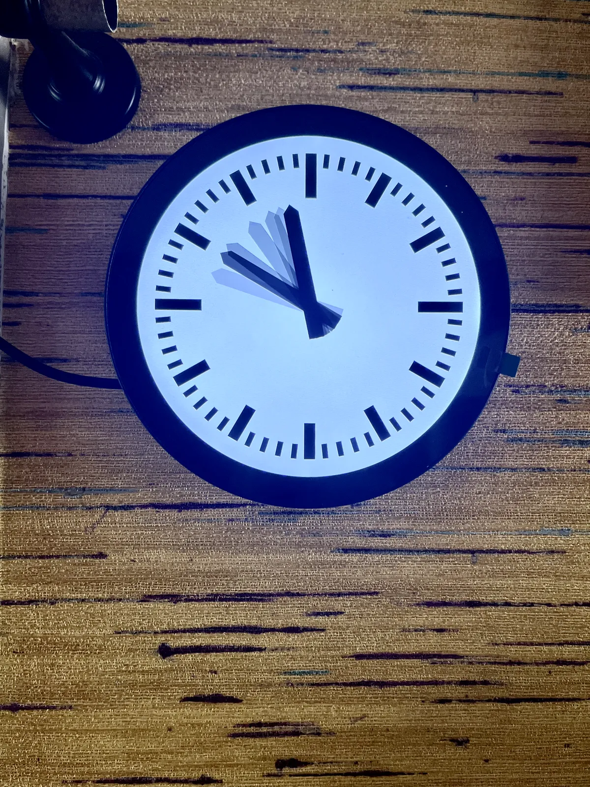 A digital version of a station clock, but this one doesn’t have a minute hand. It does have many fading hours hands though, that all point at different times, between approximately 20 to ten and 20 to 12. So it is somewhere between 20 to 10 and 20 to twelve.