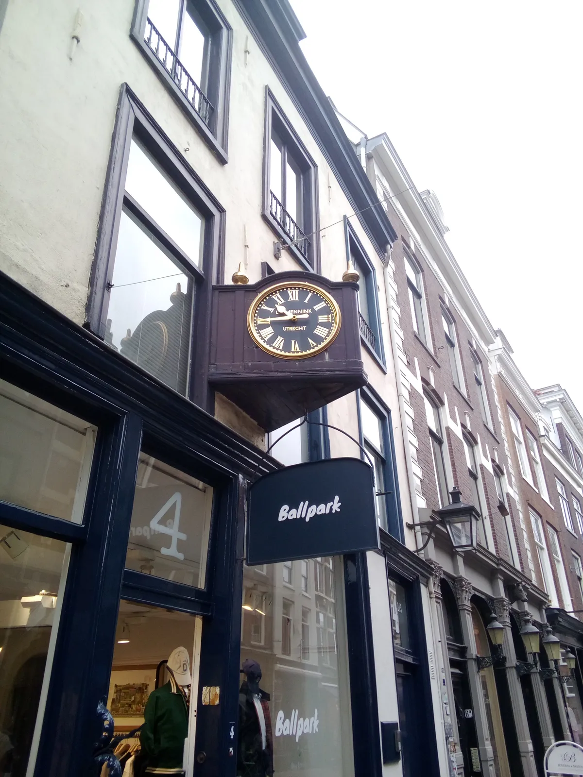Above a shopping window there’s an old clock that points at a quarter to eleven.