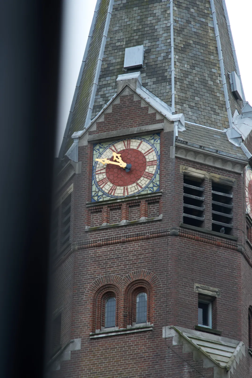 A clock on a church tower. If you look closely you can see a dove sitting on a ridge on this tower. The clock points at 11 to 11.