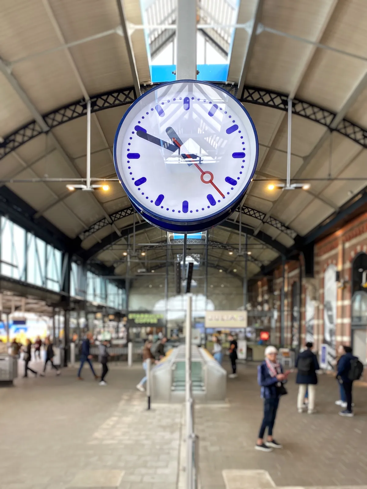 A clock in a train station in the Netherlands. It points at 11 minutes to 11.